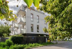 a white building with a fence in front of it at Warsaw Concierge Gocławek in Warsaw