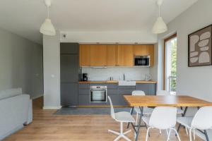 a kitchen and dining room with a table and chairs at Warsaw Concierge Gocławek in Warsaw