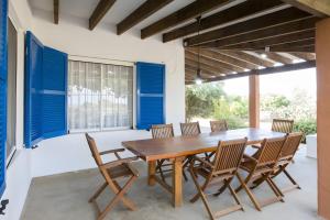 a dining room with a wooden table and chairs at Casa Rita in San Ferrán de ses Roques