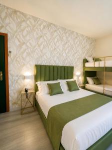 a bedroom with a large bed with a green headboard at Hotel Liu in Lido di Camaiore +49 photos