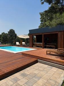 a wooden deck next to a swimming pool at Villa Ruj Retreat Deliblatska Peščara in Šumarak +17 photos