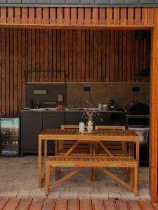 a kitchen with a wooden table and a table sidx sidx sidx at Villa Ruj Retreat Deliblatska Peščara in Šumarak