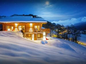 a house in the snow at night at Chalet Alti - OVO Network in Le Grand-Bornand