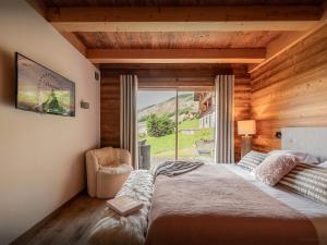 a bedroom with a large bed and a window at Chalet Alti - OVO Network in Le Grand-Bornand +40 photos