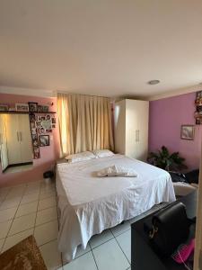 a bedroom with a bed with white sheets and pink walls at Apartamento Vista Mar Belli Golden tower in Natal +56 photos