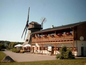 ein Gebäude mit einer Seitenwindmühle in der Unterkunft Appartements An der Muehle in Brunshaupten