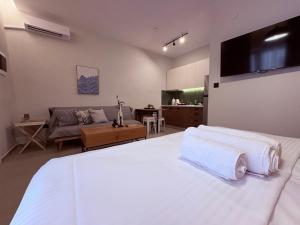 a bedroom with a white bed and a living room at Annasa Suites 1 in Mángana