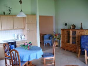 eine Küche mit einem Tisch und einem blauen Tischtuch in der Unterkunft Appartements An der Muehle in Brunshaupten