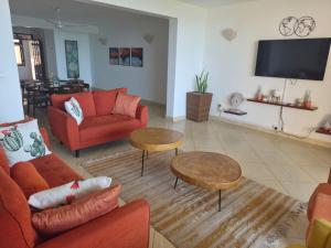 a living room with orange furniture and a flat screen tv at Ocean View Apartment D5 in Mombasa