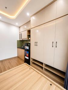 a kitchen with white cabinets and a refrigerator at Happy Hotel Phu Tho 