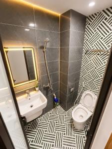 a bathroom with a white toilet and a sink at Happy Hotel Phu Tho 