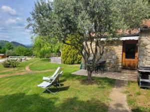 a pair of white chairs in a yard next to a building at Mas de Bouilhac 1 Gite, 1 Chambre Insolite, 1 Chambre Romantique in Pranles