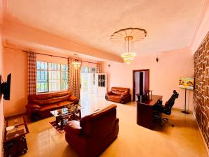 a large living room with leather furniture and a chandelier at Irebero Boutique Hotel in Butare