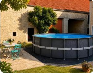 a large swimming pool in a yard next to a building at Grand gîte convivial proche de Dijon in Marey-sur-Tille