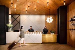 a woman walking past a reception desk in a lobby at Arlo Chicago in Chicago