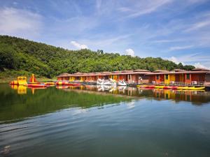 a group of houses on a river with boats at Raya Buri Resort Kanchanaburi in Ban Hin Hak