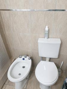 a bathroom with a white toilet and a sink at Departamento Centro Viedma in Viedma +5 photos