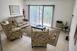 a living room with a couch and two chairs at Departamento Centro Viedma in Viedma