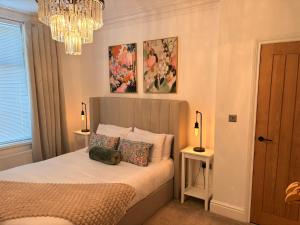 a bedroom with a bed with pillows and a chandelier at Coastal Apartments No 2 in Seaham