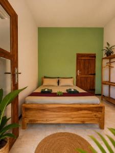 a bedroom with a bed with a green wall at Eagle Resort Arugambay in Arugam Bay