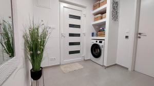 a white laundry room with a washer and dryer at Apartman Zlatan in Drniš