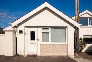 a white house with a white door at Cushendall Coastal Accommodation, Glens of Antrim - Beach & Mountain Access in Cushendall +42 photos