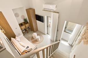 a living room with a couch and a tv at Asikiko Suites in Rethymno