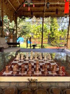 a chess board on a table in a room at Rimzim's Tatvamasi - A Pool Villa Retreat in Kudāl