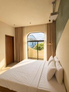 a bedroom with a large bed with a large window at Shine Home in Hue