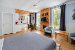 a bedroom with a bed and a living room at Manoir Charlevoix in La Malbaie