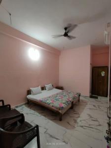 a bedroom with a bed and a ceiling fan at Hotel Madhur Palace in Bhopal