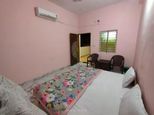 a bedroom with a bed with a blanket on it at Hotel Madhur Palace in Bhopal