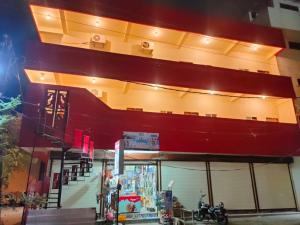a store front with a red and yellow building at Hotel Madhur Palace in Bhopal