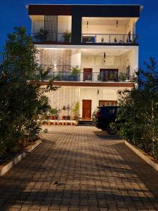 a building with a car parked in the driveway at Wind Chimes in Tiruvannāmalai