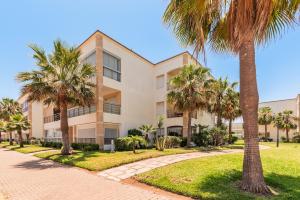 a building with palm trees in front of it at Ola Blanca - Pool - Garden in Dar Hamida