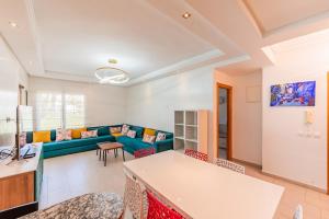 a living room with a couch and a table at Ola Blanca - Pool - Garden in Dar Hamida