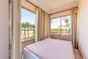 a bedroom with a bed and a large window at Ola Blanca - Pool - Garden in Dar Hamida +12 photos