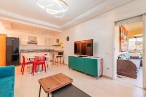 a living room with a table and a kitchen at Ola Blanca - Pool - Garden in Dar Hamida
