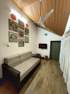 a living room with a couch and a ceiling at Rimzim's Tatvamasi - A Pool Villa Retreat in Kudāl