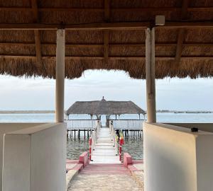a dock with an umbrella and the water at Timonier Ecolodge in Mar Lodj
