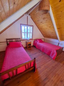 a attic bedroom with two beds in a attic at Cabañas Ruidos de Agua in Choele Choel