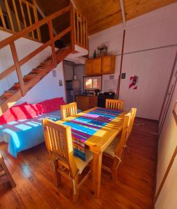 a dining room with a table and chairs and a bed at Cabañas Ruidos de Agua in Choele Choel