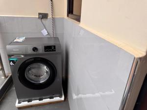 a washer and dryer in a corner of a room at Mallony Homes in Kampala +1 photo