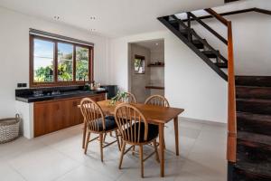 a kitchen and dining room with a wooden table and chairs at Dream Nest Bali in Munggu