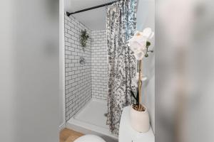 a bathroom with a shower with a vase with a flower at Bright 2 Bedroom Suite in Windsor