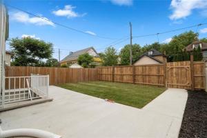 a backyard with a wooden fence and grass at Bright 2 Bedroom Suite in Windsor