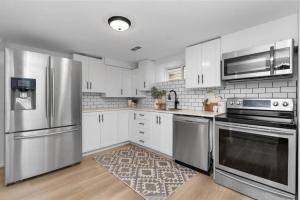 a kitchen with stainless steel appliances and white cabinets at Bright 2 Bedroom Suite in Windsor