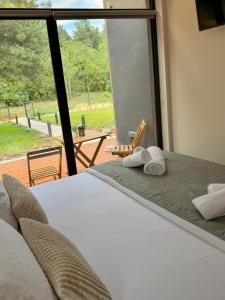 a bedroom with a bed and a large window at Villa Ruj Retreat Deliblatska Peščara in Šumarak