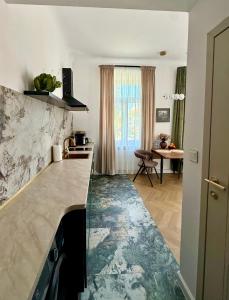a kitchen with a marble counter top and a table at Apartament Verde Stare Miasto in Chełm