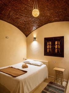 a bedroom with a bed in a room with a ceiling at Cafour House Siwa - Hot Spring in Siwa